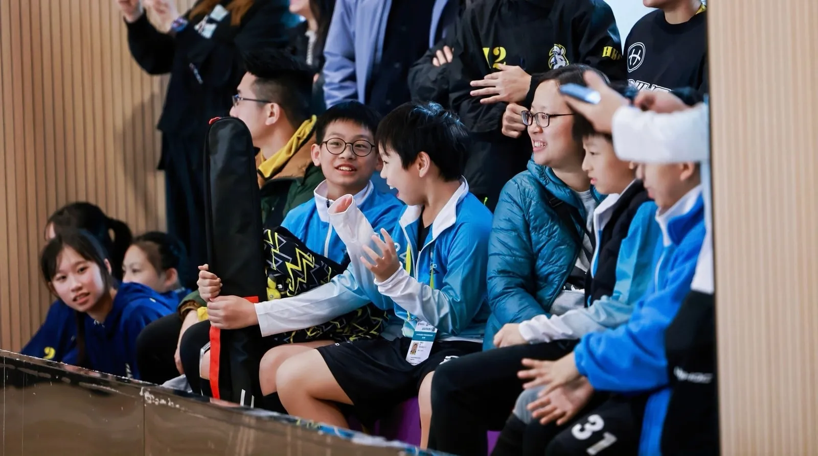 Young players and coaches seated together on the sideline