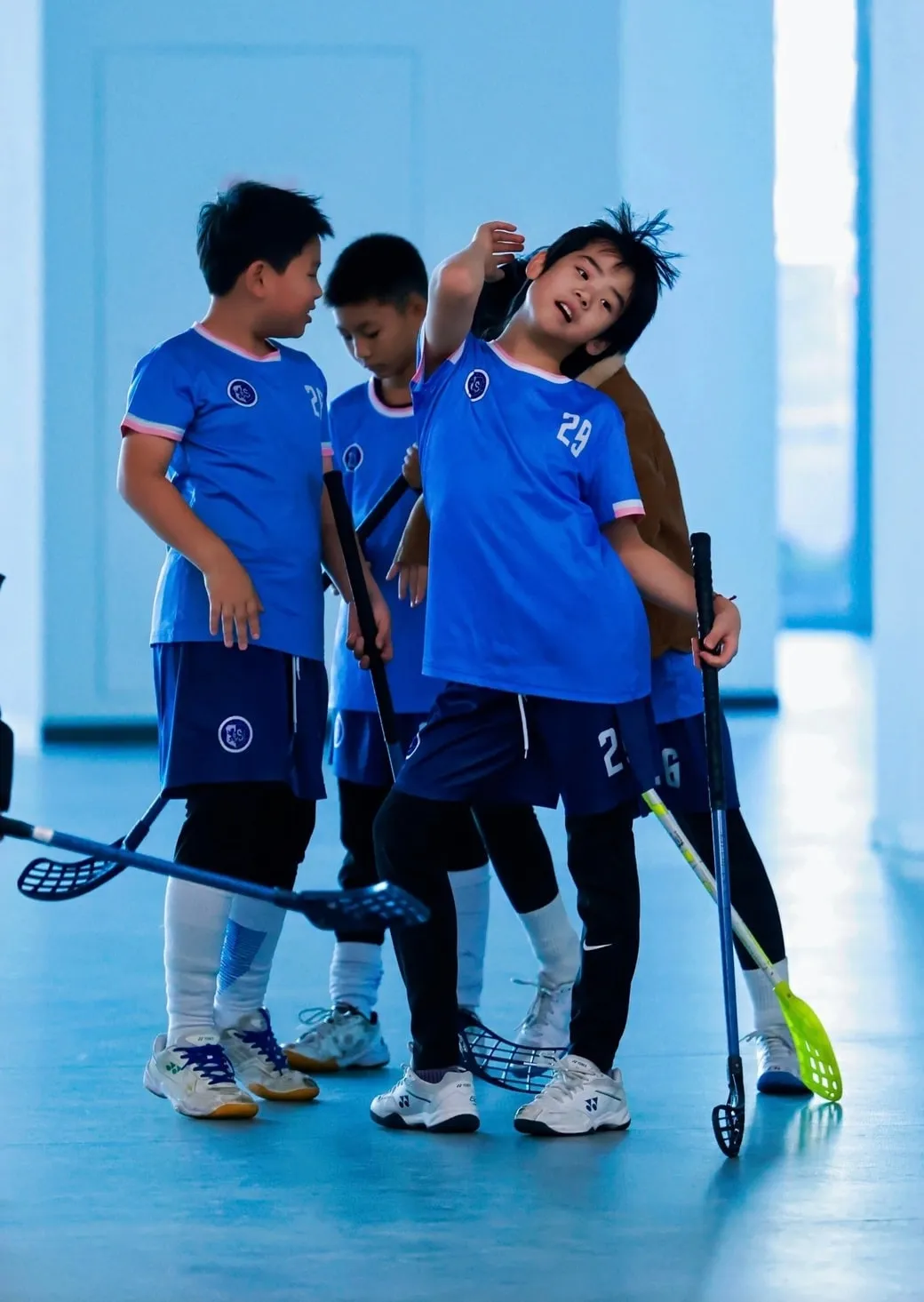 Three young players in blue jerseys laughing together
